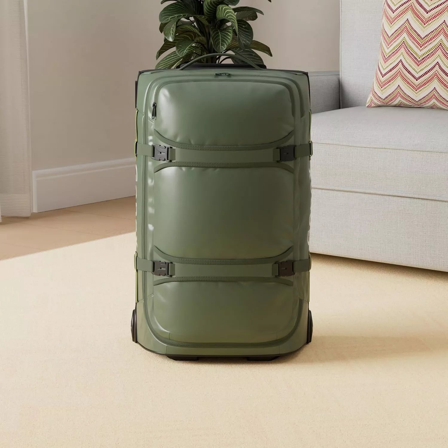 Green 25 inch gonex rolling duffle bag on a beige carpet